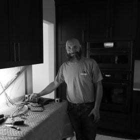 Jason Hoffman installing under cabinet lights; Des Moines, Iowa.