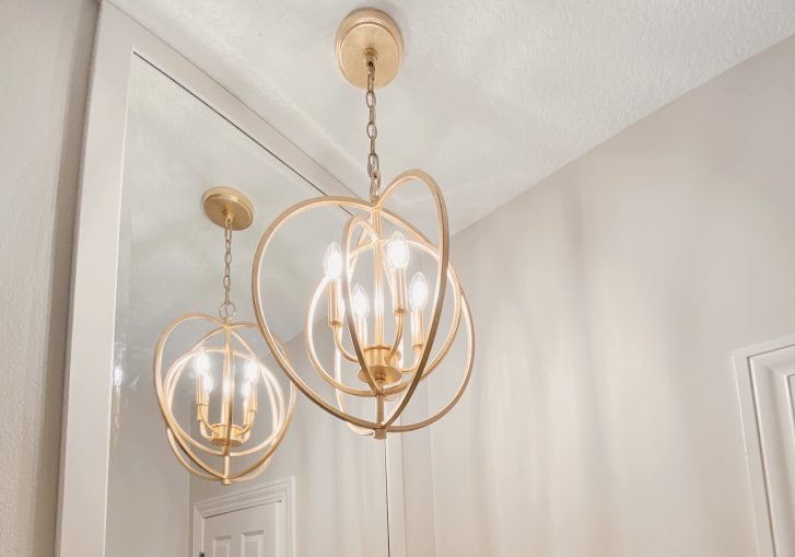 Bronze light fixture works with the mirror to illuminate the space.