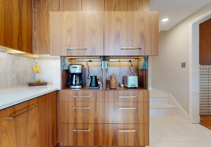 This mid-century modern kitchen remodel embraces clean lines, natural materials, and functional elegance. At its heart are our Signature Cornerstone custom grain-matched walnut cabinets in a rich natural finish, offering a seamless, sophisticated look.