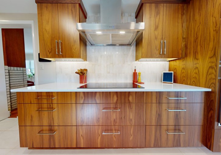 This mid-century modern kitchen remodel embraces clean lines, natural materials, and functional elegance. At its heart are our Signature Cornerstone custom grain-matched walnut cabinets in a rich natural finish, offering a seamless, sophisticated look.