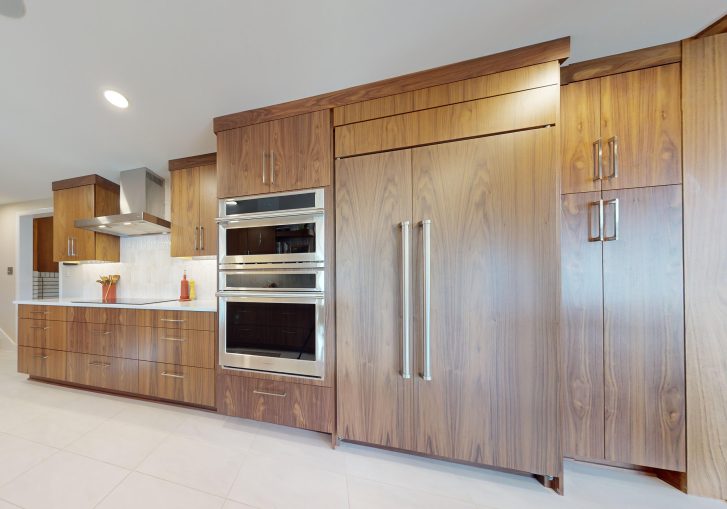 This mid-century modern kitchen remodel embraces clean lines, natural materials, and functional elegance. At its heart are our Signature Cornerstone custom grain-matched walnut cabinets in a rich natural finish, offering a seamless, sophisticated look.