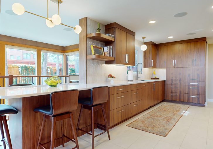 This mid-century modern kitchen remodel embraces clean lines, natural materials, and functional elegance. At its heart are our Signature Cornerstone custom grain-matched walnut cabinets in a rich natural finish, offering a seamless, sophisticated look.