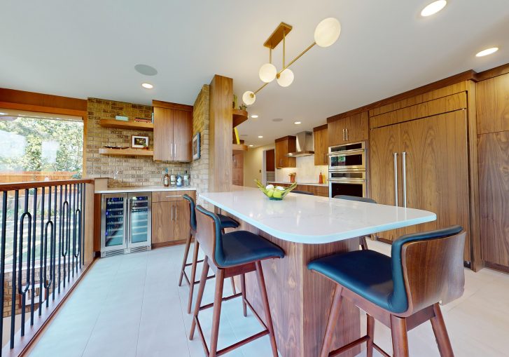 This mid-century modern kitchen remodel embraces clean lines, natural materials, and functional elegance. At its heart are our Signature Cornerstone custom grain-matched walnut cabinets in a rich natural finish, offering a seamless, sophisticated look.