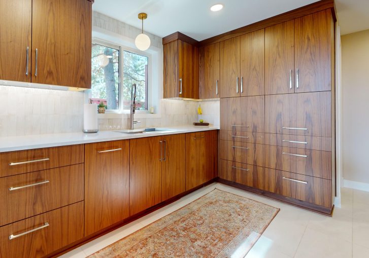 This mid-century modern kitchen remodel embraces clean lines, natural materials, and functional elegance. At its heart are our Signature Cornerstone custom grain-matched walnut cabinets in a rich natural finish, offering a seamless, sophisticated look.