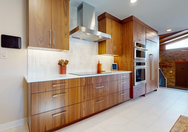 This mid-century modern kitchen remodel embraces clean lines, natural materials, and functional elegance. At its heart are our Signature Cornerstone custom grain-matched walnut cabinets in a rich natural finish, offering a seamless, sophisticated look.