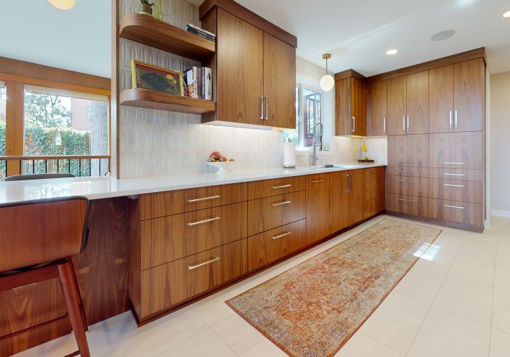 This mid-century modern kitchen remodel embraces clean lines, natural materials, and functional elegance. At its heart are our Signature Cornerstone custom grain-matched walnut cabinets in a rich natural finish, offering a seamless, sophisticated look.