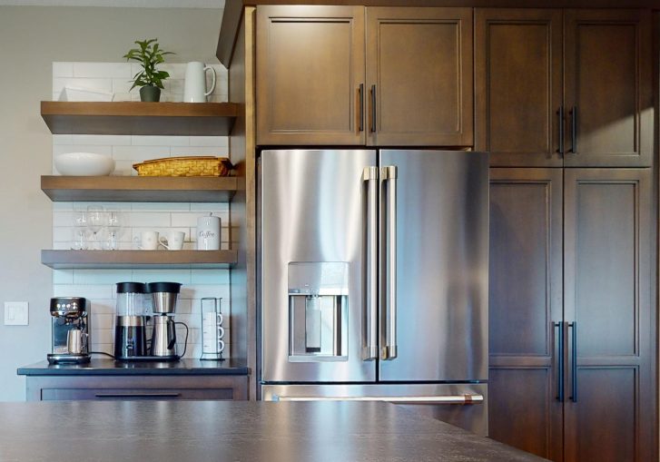 For coffee lovers, this remodel includes a dedicated coffee bar area. With floating shelves installed above, this space is both functional and stylish. The open shelving allows for easy access to coffee mugs and supplies while offering a chance to showcase decorative items that add a personal touch to the kitchen.