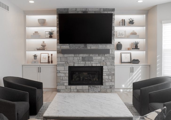 Flanking the fireplace are custom built-in cabinets from Cornerstone Cabinetry, offering both functional storage and a polished, high-end look.