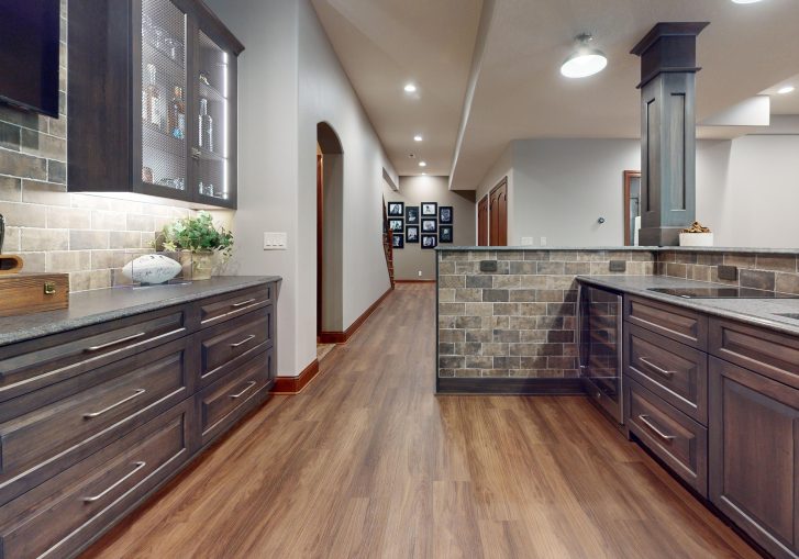 Exposed brick wall accents lend an authentic, urban speakeasy vibe. The brick's natural texture and tone create visual depth and contrast, grounding the space and connecting it to its historical inspiration.